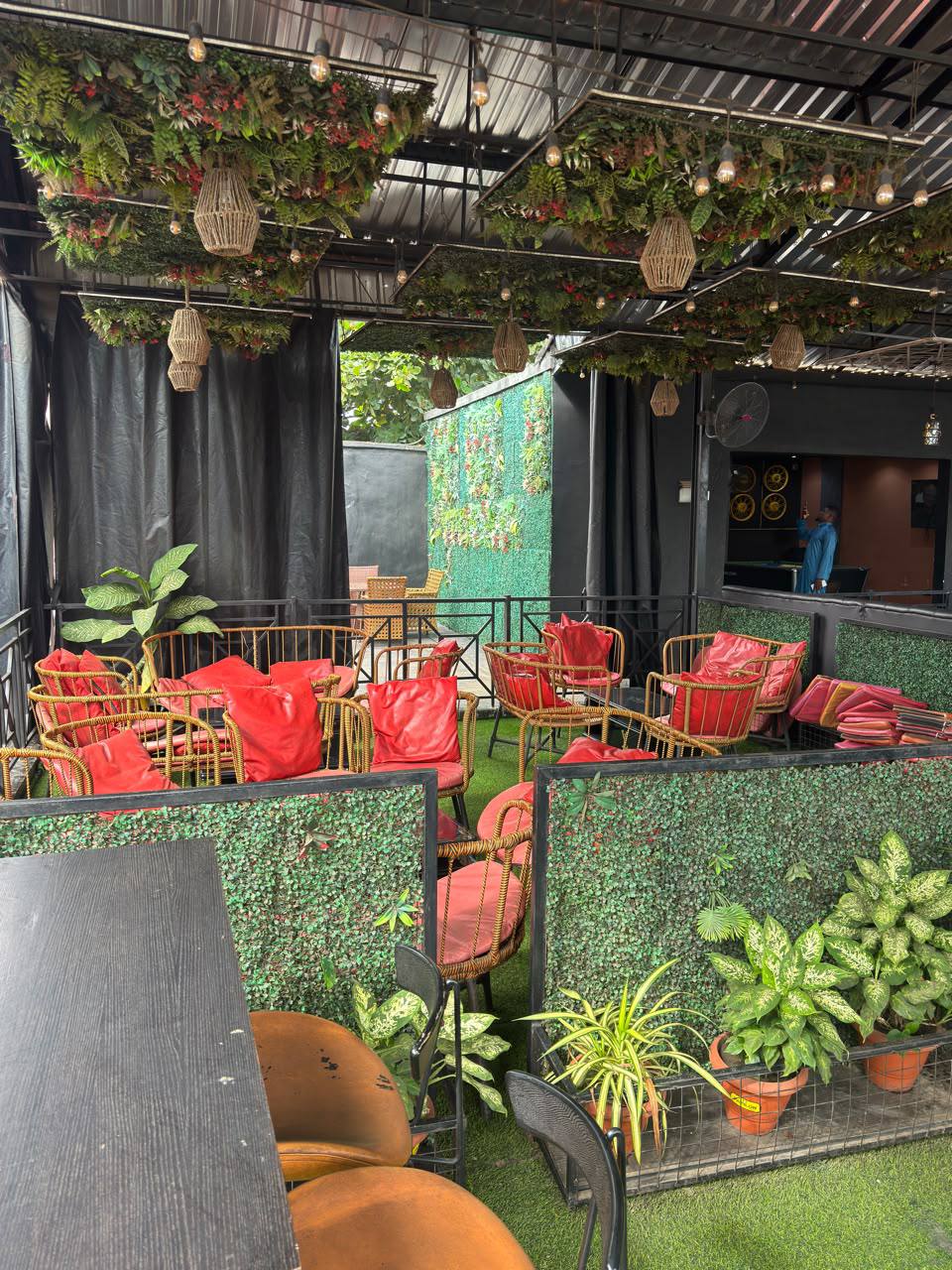 Nova Arena outdoor VIP seating with red cushions and hanging greenery