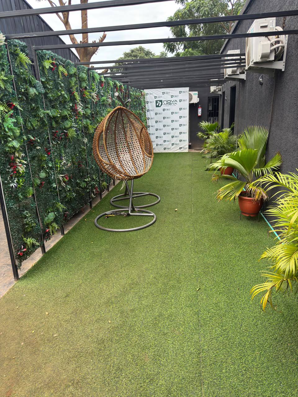 Nova Arena garden walkway with hanging chair and potted palms